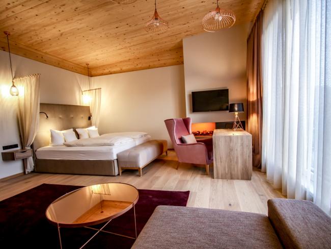 Modernes Zimmer im Pfalzblick Wald Spa Resort mit Bett und gemütlichem Sessel