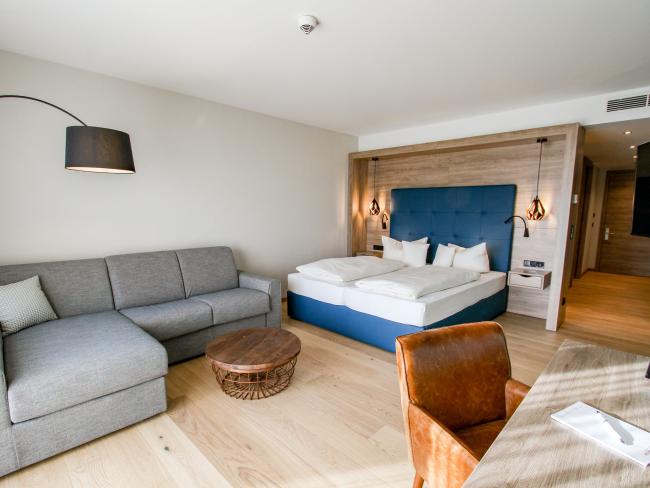 Modernes Hotelzimmer im Pfalzblick Wald Spa Resort mit Bett und Sofa