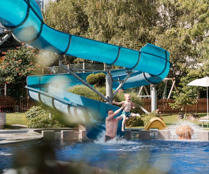 Vater und Sohn rutschen im TYROL Family Retreat.
