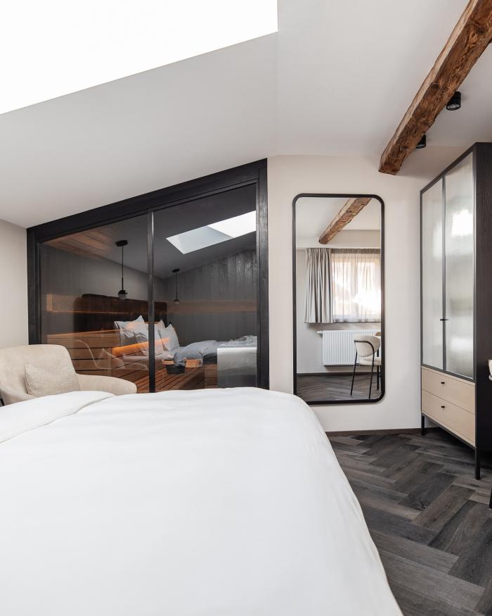Modernes Schlafzimmer mit Schwarzer Adler Sauna und Holzbalken
