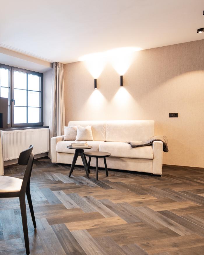 Modern eingerichtetes Wohnzimmer im Schwarzer Adler Hotel mit Sofa und TV