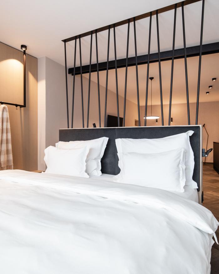 Modernes Schlafzimmer mit weißer Bettwäsche im Schwarzer Adler Hotel