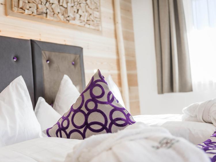 Gemütliches Hotelzimmer mit ordentlich gemachten Betten und dekorativen Kissen.