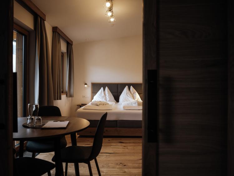 Hotel Forstauerwirt: Blick durch die Tür auf ein Zimmer mit Bett, Tisch und Stühlen