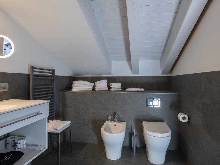 Modern bathroom at Hotel Touring Verona with bidet and toilet under slanted ceiling