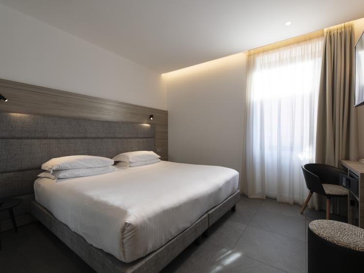 Modern double room at Hotel Touring Verona with large bed and desk