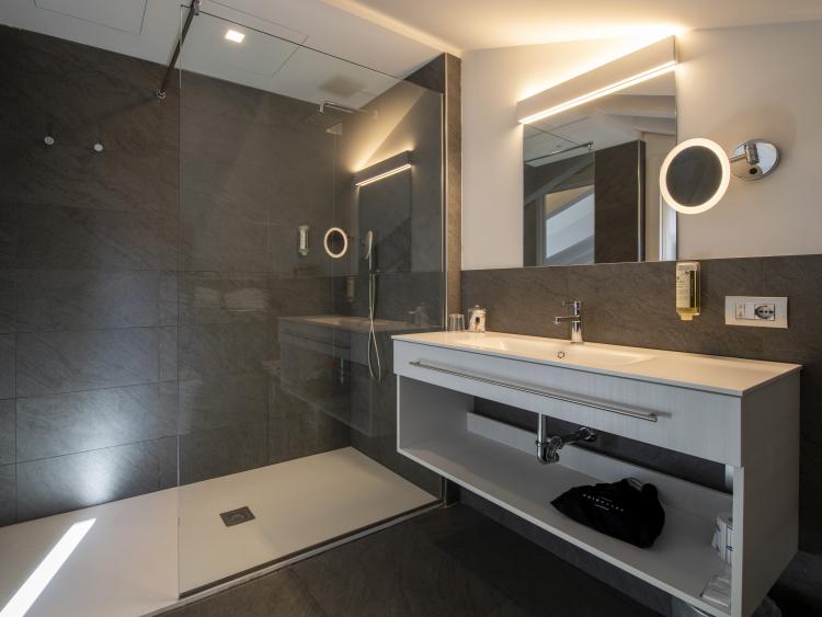 Modern bathroom at Hotel Touring Verona with large shower and illuminated mirror