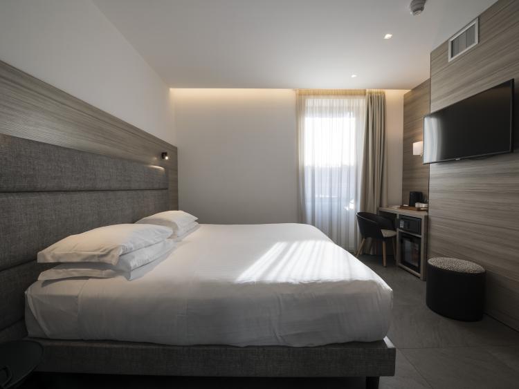 Modern hotel room at Hotel Touring Verona with sofa and TV