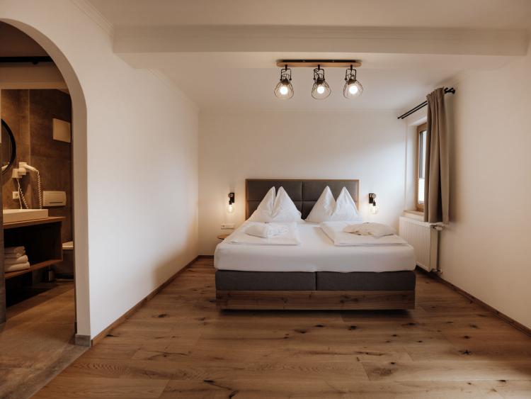 Schlafzimmer im Hotel Forstauerwirt mit Doppelbett und Holzboden