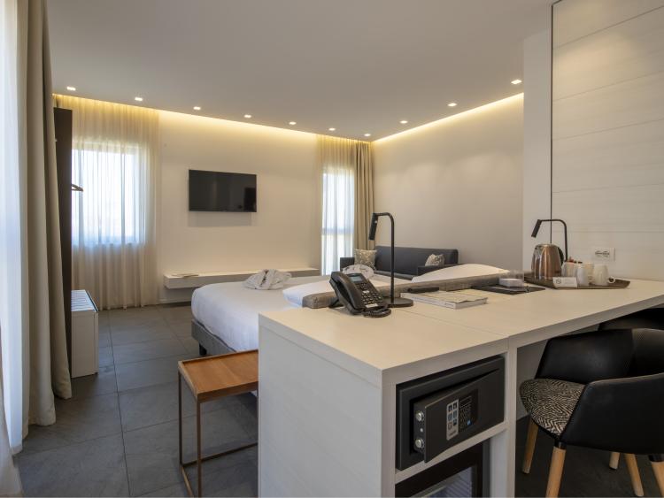 Modern hotel room at Hotel Touring Verona with bed, TV, and desk