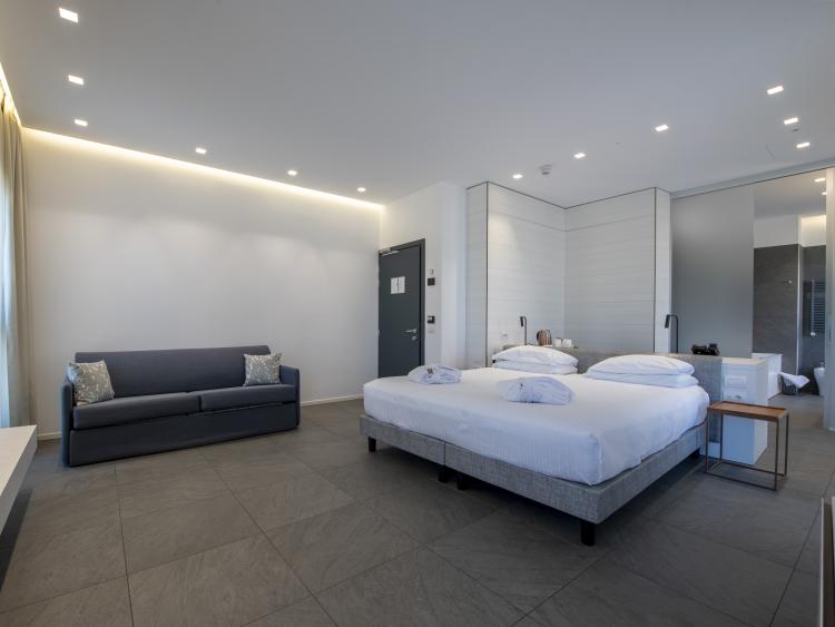 Modern hotel room at Hotel Touring Verona with double bed and sofa