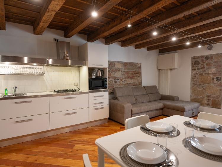 Kitchen and living area with dining table at Hotel Touring Verona