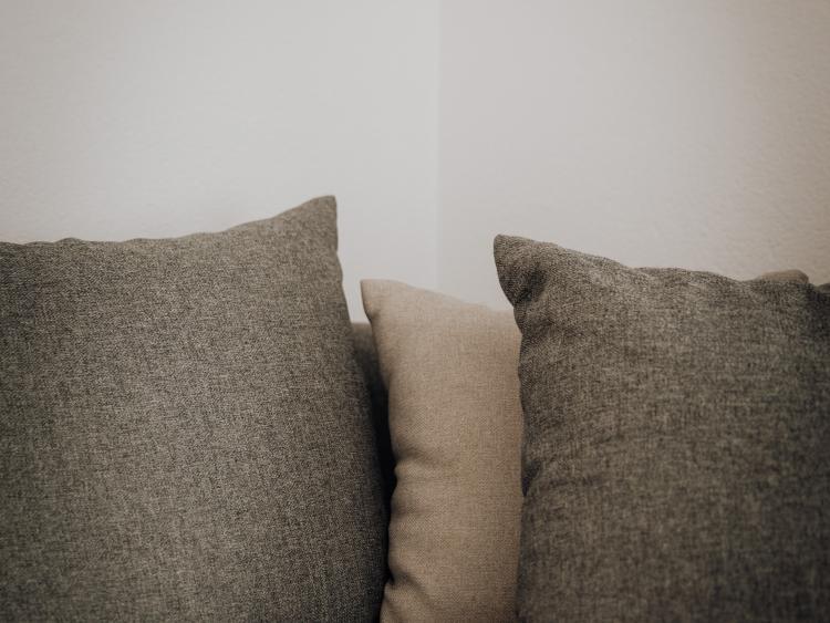 Graue und beige Kissen auf einem Sofa im Hotel Forstauerwirt
