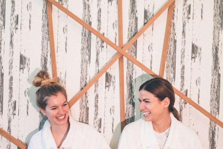 Eibl-Brunner: Zwei Frauen in Bademänteln lachen im Spa-Bereich