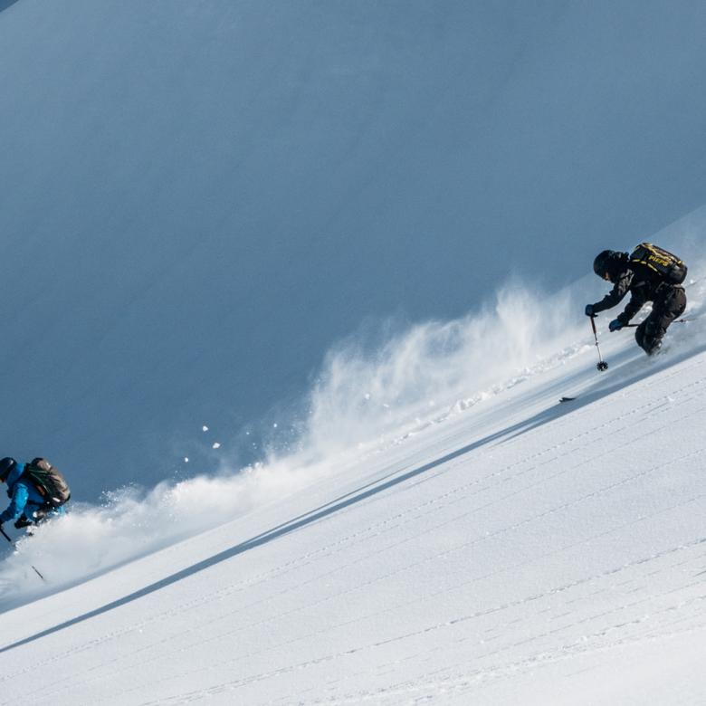 Zwei Skifahrer fahren am Hang mit Schnee bei Hotel Aurora