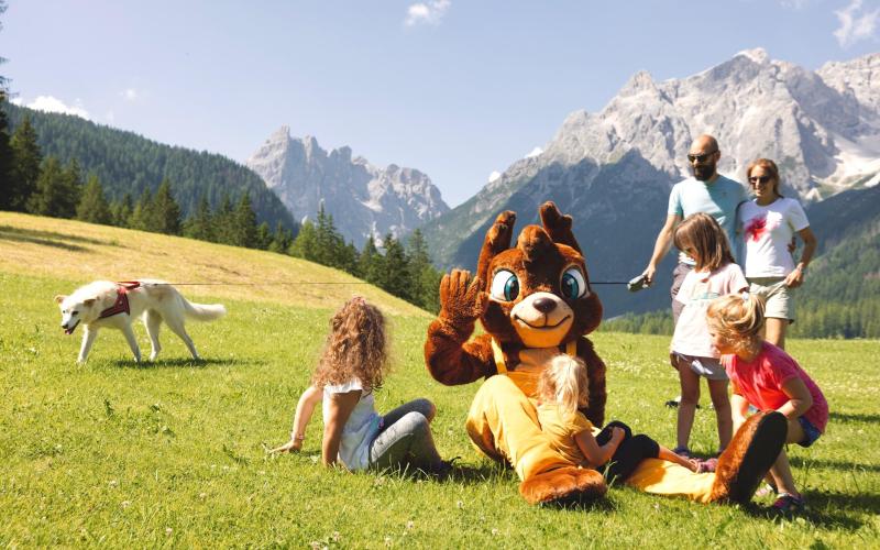 Hotel Rainer: Familie mit Hund und Maskottchen auf grüner Bergwiese