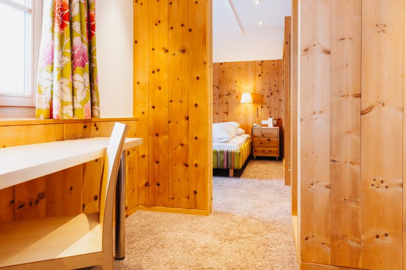 Cozy room at Hotel Aurora with wooden walls and white bedding