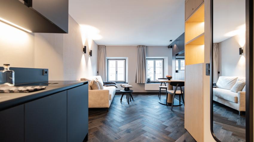 Modernes Wohnzimmer im Schwarzer Adler mit dunklem Parkett und gemütlicher Sofaecke