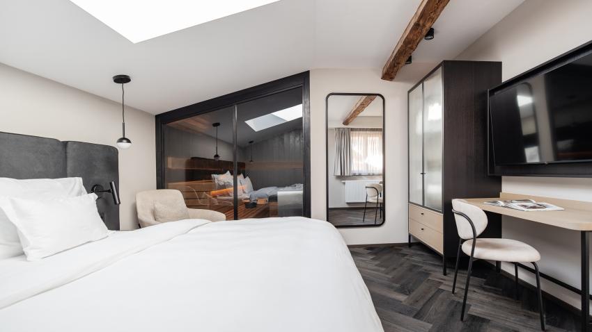 Modernes Schlafzimmer mit Schwarzer Adler Sauna und Holzbalken
