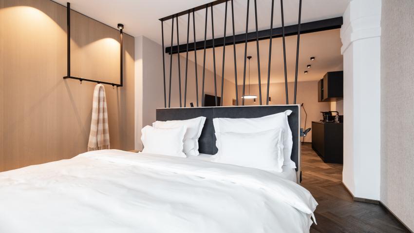 Modernes Schlafzimmer mit weißer Bettwäsche im Schwarzer Adler Hotel